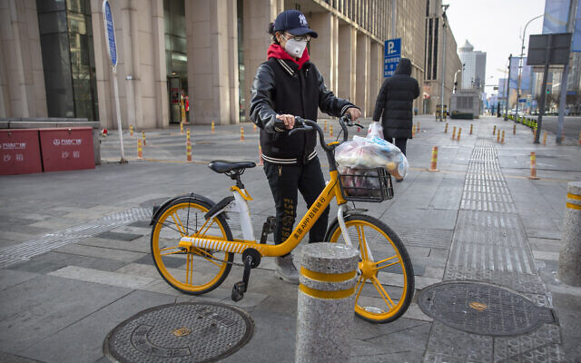 A woman wears a face mask as she pushes a bicycle along a street in Beijing, Saturday, Feb. 1, 2020. (AP/Mark Schiefelbein) A woman wears a face mask as she pushes a bicycle along a street in Beijing, Saturday, Feb. 1, 2020. (AP/Mark Schiefelbein)