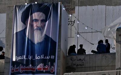 In this Feb. 1, 2020 photo, a poster of Grand Ayatollah Ali al-Sistani is on display with Arabic that reads, 'Peace, father of Iraq,' in Tahrir Square, Baghdad, Iraq  (AP Photo/Khalid Mohammed)