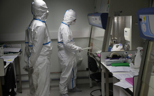 French lab scientists in hazmat gear inserting liquid in test tube manipulate potentially infected patient samples at Pasteur Institute in Paris, Feb. 6, 2020 (AP Photo/Francois Mori) French lab scientists in hazmat gear inserting liquid in test tube manipulate potentially infected patient samples at Pasteur Institute in Paris, Feb. 6, 2020 (AP Photo/Francois Mori)