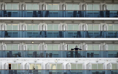 A passenger stands on the balcony of the cruise ship Diamond Princess anchored at the Yokohama Port in Yokohama, near Tokyo, Feb. 7, 2020 (AP Photo/Eugene Hoshiko)