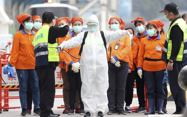 An epidemic prevention worker in a protective suit stands by to get on board the cruise ship SuperStar Aquarius docked at Keelung port in New Taipei City, Taiwan, Saturday, Feb, 8, 2020. (AP/Chiang Ying-ying) An epidemic prevention worker in a protective suit stands by to get on board the cruise ship SuperStar Aquarius docked at Keelung port in New Taipei City, Taiwan, Saturday, Feb, 8, 2020. (AP/Chiang Ying-ying)