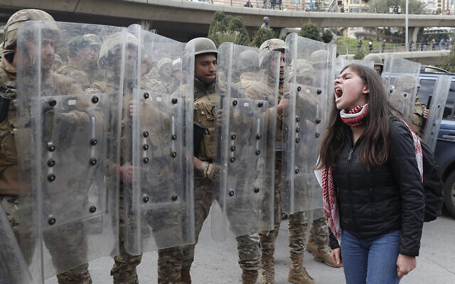 A protester shouts slogans in front of army soldiers during a protest against a parliament session vote of confidence for the new government in downtown Beirut, Lebanon, Feb. 11, 2020 (AP Photo/Hussein Malla) A protester shouts slogans in front of army soldiers during a protest against a parliament session vote of confidence for the new government in downtown Beirut, Lebanon, Feb. 11, 2020 (AP Photo/Hussein Malla)