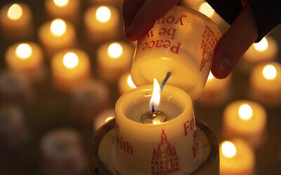 A child lights a candle in the Frauenkirche cathedral (Church of Our Lady) in Dresden, Germany, February 11, 2020. (Jens Meyer/AP)