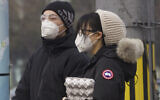 Residents wearing masks wait at a traffic light in Beijing, China, on February 13, 2020. (AP Photo/Ng Han Guan)