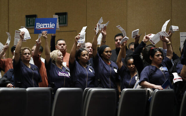 Casino workers hold up presidential preference cards as they support Democratic presidential candidate Sen. Bernie Sanders of Vermont during a presidential caucus at the Bellagio hotel-casino on February 22, 2020 in Las Vegas, Nevada. (AP/John Locher) Casino workers hold up presidential preference cards as they support Democratic presidential candidate Sen. Bernie Sanders of Vermont during a presidential caucus at the Bellagio hotel-casino on February 22, 2020 in Las Vegas, Nevada. (AP/John Locher)