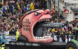 A carnival float depicts a racist with a gun in his mouth , reading 'from words to action' during the traditional carnival parade in Duesseldorf, Germany, on February 24, 2020. (Martin Meissner/AP)