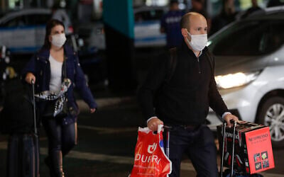 Passengers wearing masks as a precaution against the spread of the new coronavirus COVID-19 arrive to the Sao Paulo International Airport in Sao Paulo, Brazil, Wednesday, Feb. 26, 2020. (AP/Andre Penner)