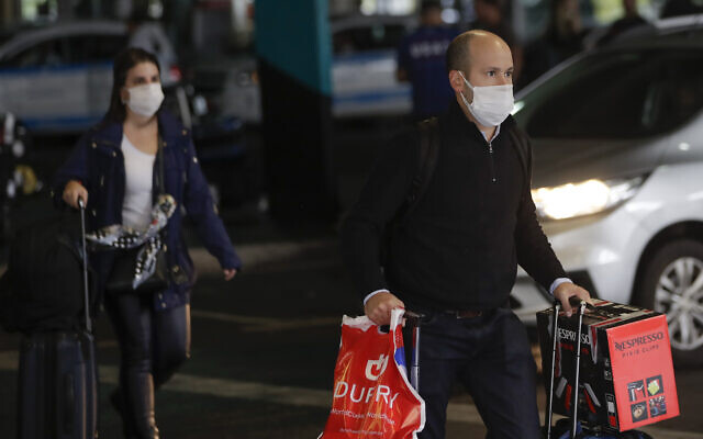 Passengers wearing masks as a precaution against the spread of the new coronavirus COVID-19 arrive to the Sao Paulo International Airport in Sao Paulo, Brazil, Wednesday, Feb. 26, 2020. (AP/Andre Penner) Passengers wearing masks as a precaution against the spread of the new coronavirus COVID-19 arrive to the Sao Paulo International Airport in Sao Paulo, Brazil, Wednesday, Feb. 26, 2020. (AP/Andre Penner)