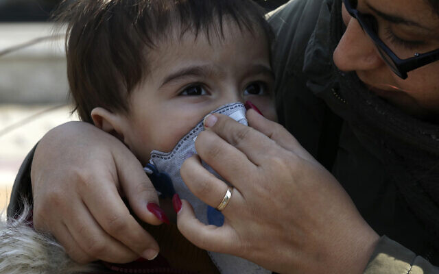A woman helps his boy to put on a mask in downtown Tehran, Iran, February 27, 2020. (AP Photo/Vahid Salemi) A woman helps his boy to put on a mask in downtown Tehran, Iran, February 27, 2020. (AP Photo/Vahid Salemi)