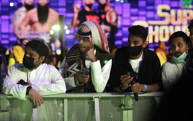 Some of the wrestling fans wear protective masks as they watch wrestling matches of the WWE Super ShowDown in Riyadh, Saudi Arabia, late Feb. 27, 2020 (AP Photo/Amr Nabil) Some of the wrestling fans wear protective masks as they watch wrestling matches of the WWE Super ShowDown in Riyadh, Saudi Arabia, late Feb. 27, 2020 (AP Photo/Amr Nabil)