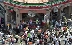 Police and medics surround the scene of a suicide bombing inside Jerusalem's Sbarro restaurant, Thursday, August 9, 2001. Fifteen people were killed, and 130 injured. A sixteenth victim died in 2023. (AP/Peter Dejong)