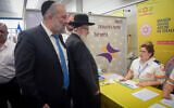 Interior Minister Aryeh Deri, left, and Health Minister Yaakov Litzman visit medical personnel at Ben Gurion International Airport following reports about the deadly coronavirus, February 02, 2020. (Avshalom Shoshani/Flash90)