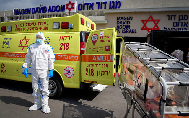 Magen David Adom worker wears protective clothing as a preventive measure against the coronavirus outside the special emergency Call Center in Kiryat Ono on February 26, 2020 (Flash90) Magen David Adom worker wears protective clothing as a preventive measure against the coronavirus outside the special emergency Call Center in Kiryat Ono on February 26, 2020 (Flash90)