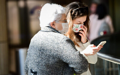 People wearing face masks against the coronavirus at Ben Gurion Airport on February 27, 2020. (Avshalom Shoshani/Flash90)