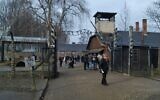 Visitors walk through the infamous gate reading 'Arbeit Macht Frei,' or 'work sets you free,' at the former site of Auschwitz-Birkenau, January 28, 2020. (Yaakov Schwartz/Times of Israel)