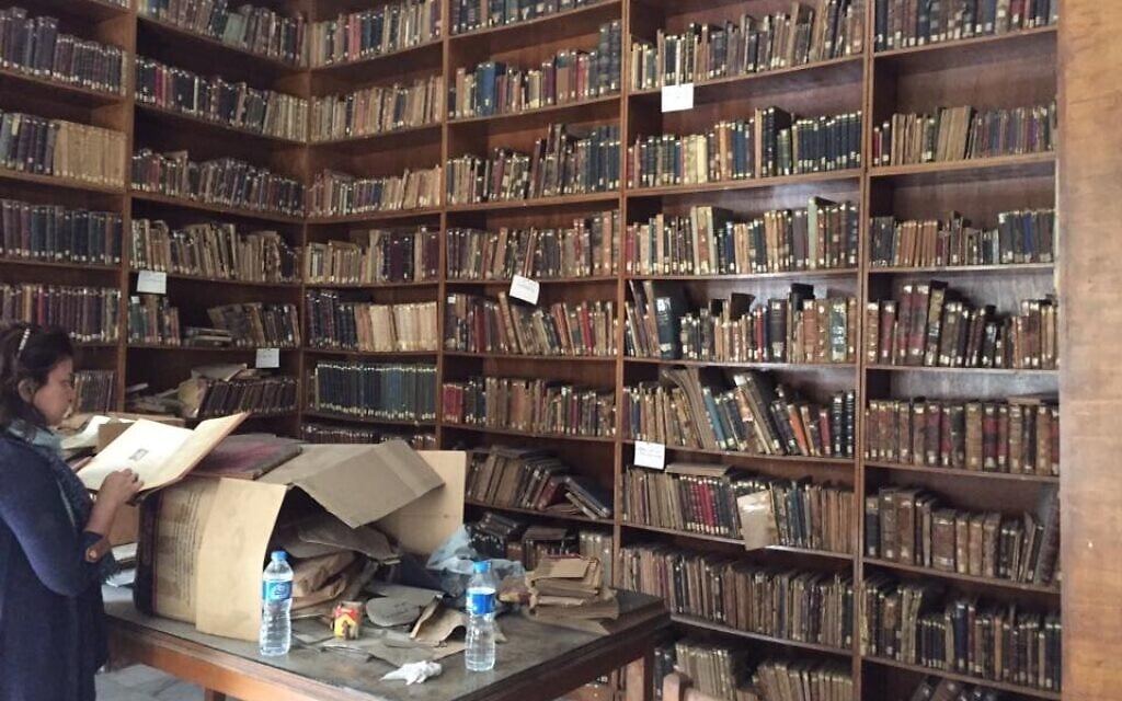 Marwa digs through documents at the Karaite archive.The community faces the challenge of safely storing, categorizing and protecting the many long-neglected documents that are still in the country. (Courtesy)