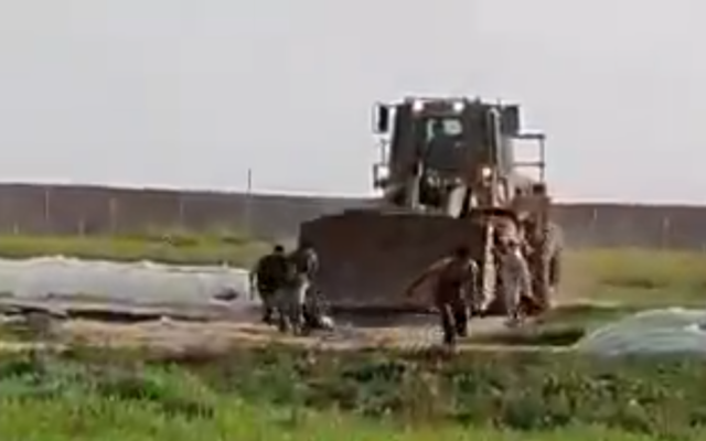 An Israeli military bulldozer enters the Gaza buffer zone to retrieve the body of a suspected terrorist on February 23, 2020. (Screen capture/Shehab news) An Israeli military bulldozer enters the Gaza buffer zone to retrieve the body of a suspected terrorist on February 23, 2020. (Screen capture/Shehab news)