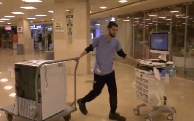 An employee of Rambam Medical Center in Haifa moves equipment to a special wing being set up at the hospital to treat the coronavirus, February 29, 2019. (Screen capture: Twitter)