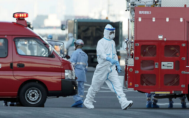 An official walks near the cruise ship Diamond Princess anchored off the Yokohama Port in Yokohama, near Tokyo, February 10, 2020. (AP/Eugene Hoshiko) An official walks near the cruise ship Diamond Princess anchored off the Yokohama Port in Yokohama, near Tokyo, February 10, 2020. (AP/Eugene Hoshiko)
