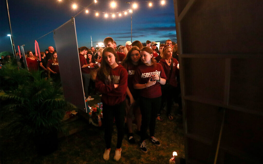 Mourners at an anniversary memorial for the victims of the Parkland, Fla., shooting, Feb. 14, 2019, in Parkland, Fla. (AP Photo/Wilfredo Lee)