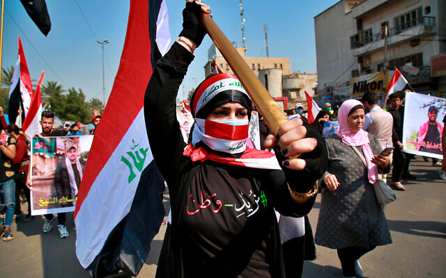An anti-government protester holds an Iraqi flag during demonstrations in Baghdad, Iraq, Feb. 23, 2020. (AP Photo/Khalid Mohammed) An anti-government protester holds an Iraqi flag during demonstrations in Baghdad, Iraq, Feb. 23, 2020. (AP Photo/Khalid Mohammed)