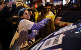 Feminist activists paste posters on police vehicles outside Cesar Film Awards Ceremony in Paris as guests arrive, February 28, 2020. (Lucas Barioulet/AFP)