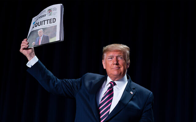 US President Donald Trump holds up a newspaper with a headline that reads "ACQUITTED" during the 68th annual National Prayer Breakfast, at the Washington Hilton, Feb. 6, 2020, in Washington. (AP Photo/ Evan Vucci) US President Donald Trump holds up a newspaper with a headline that reads "ACQUITTED" during the 68th annual National Prayer Breakfast, at the Washington Hilton, Feb. 6, 2020, in Washington. (AP Photo/ Evan Vucci)