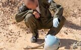 An airman inspects the helmet of an Israeli pilot who died in a plane crash in southern Israel in 1984, in the Paran desert in February 2020. (Israel Defense Forces)