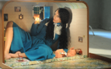 Actress and artist Raida Alon sets up house in a refitted suitcase of her own making, part of her one-woman video work, 'Strangeness,' at the Israel Museum through October 2020 (Courtesy Israel Museum)