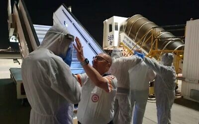 Staff prepare to receive Israelis on a Korean Air plane that landed in Israel, with some 200 other passengers to be refused entry to the country over virus fears (Magen David Adom)