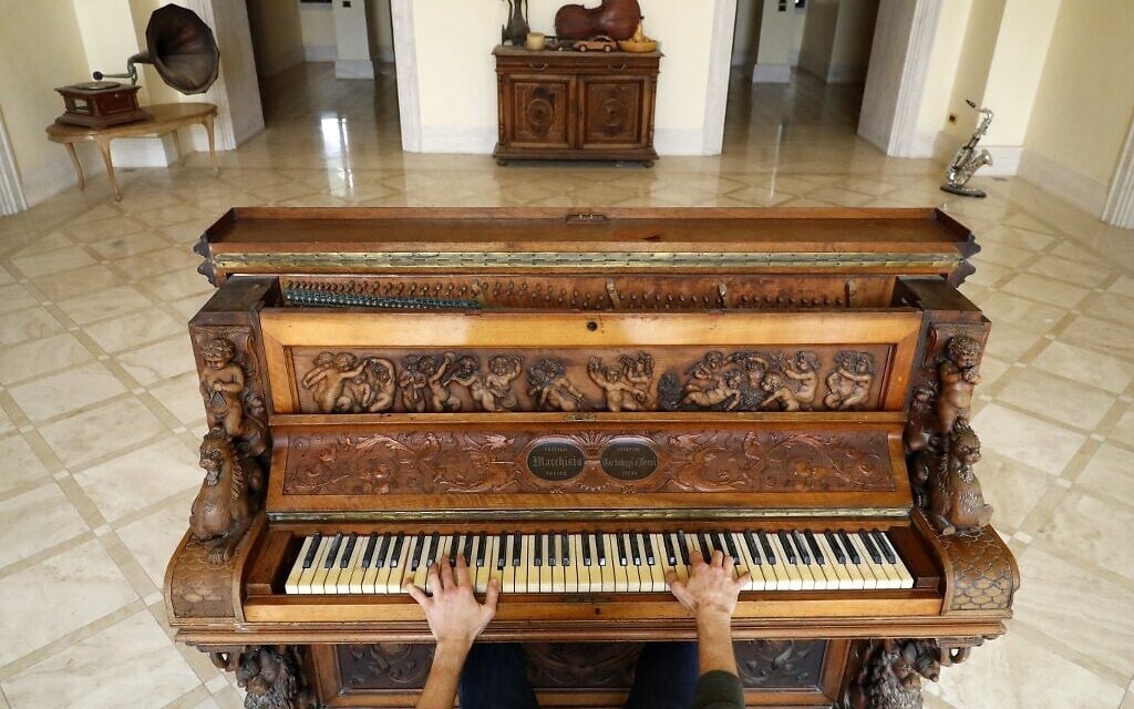 A man plays the Piano of Siena, a 19th century instrument that disappeared for decades and was expected to fetch more than $1 million when put up for auction, seen in a home in the Israeli coastal city of Caesarea, February 18, 2020. (JACK GUEZ / AFP)