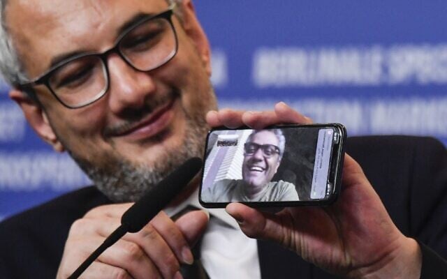 Iranian producer Farzad Pak holds a phone displaying Iranian director Mohammad Rasoulof who was awarded the "Golden Bear for Best Film" attends a press conference after the awarding ceremony of the 70th Berlinale film festival in Berlin on February 29, 2020. (Photo by John MACDOUGALL / AFP) Iranian producer Farzad Pak holds a phone displaying Iranian director Mohammad Rasoulof who was awarded the "Golden Bear for Best Film" attends a press conference after the awarding ceremony of the 70th Berlinale film festival in Berlin on February 29, 2020. (Photo by John MACDOUGALL / AFP)