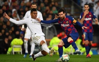 Real Madrid's midfielder Casemiro (L) challenges Barcelona's forward Lionel Messi during the Spanish League soccer match between Real Madrid and Barcelona at the Santiago Bernabeu stadium in Madrid on March 1, 2020. (Gabriel Bouys/AFP)