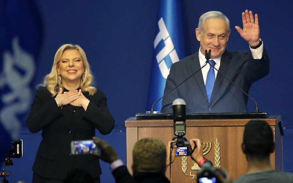 Prime Minister Benjamin Netanyahu (right) and his wife Sara address supporters at the Likud party campaign headquarters in the coastal city of Tel Aviv early on March 3, 2020, after polls officially closed. (GIL COHEN-MAGEN / AFP)