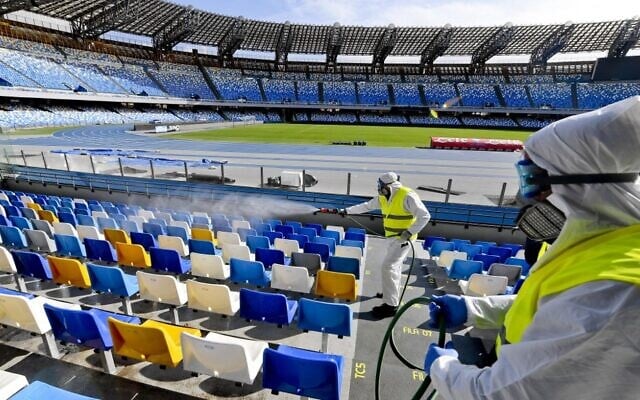 Cleaners wearing protective suits as they sanitize the seats of the San Paolo stadium in Naples, Italy, March 4, 2020. (CIRO FUSCO/ANSA/AFP) Cleaners wearing protective suits as they sanitize the seats of the San Paolo stadium in Naples, Italy, March 4, 2020. (CIRO FUSCO/ANSA/AFP)