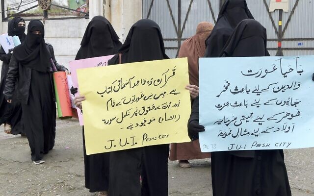 Burqa-clad female activists of Islamic political party Jamiat Ulema-e-Islam (JUI-F), carry placards during a rally to mark the International Women's Day in Peshawar on March 8, 2020 (Abdul MAJEED / AFP)