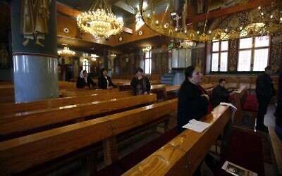 A small group of worshippers attend mass at an Orthodox church in Beit Sahour near the West Bank city of Bethlehem on March 8, 2020. (Musa Al Shaer/AFP)