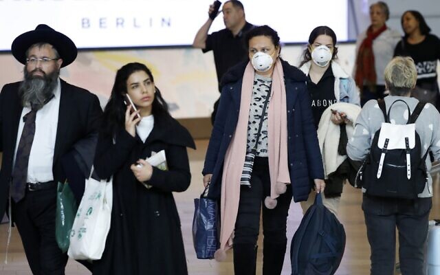 Passengers wearing protective masks in the arrivals halls at Ben Gurion International Airport near Tel Aviv on March 10, 2020. (Jack Guez/AFP) Passengers wearing protective masks in the arrivals halls at Ben Gurion International Airport near Tel Aviv on March 10, 2020. (Jack Guez/AFP)