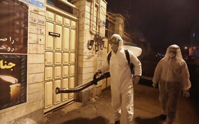 Iranian firefighters disinfect streets and alleys in southern Tehran to halt the spread of coronavirus on March 11, 2020 (ATTA KENARE / AFP)