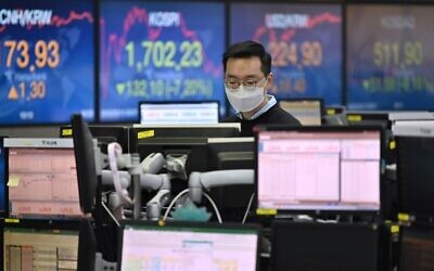 A currency dealer wearing a face mask monitors exchange rates in a trading room at KEB Hana Bank in Seoul on March 13, 2020 (Jung Yeon-je / AFP)