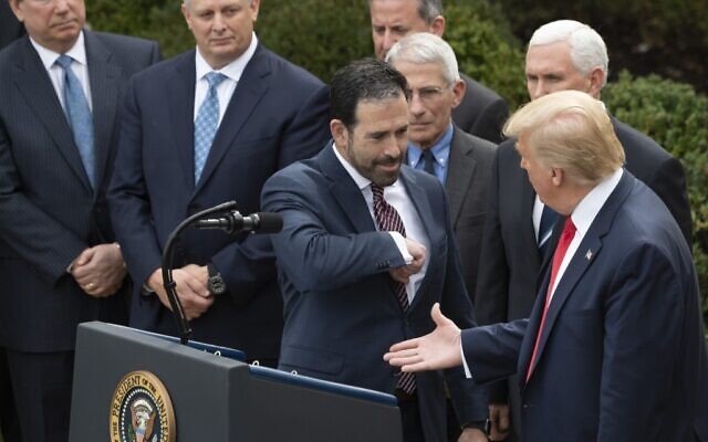 Executive VP and Chief Strategy & Innovation Officer for LHC Group Inc. Bruce Greenstein (C) offers an elbow bump  as US President Donald Trump reaches for a handshake during a press conference on COVID-19, known as the coronavirus, in the Rose Garden of the White House in Washington, DC, March 13, 2020. - Trump is declaring coronavirus a national emergency. (Photo by JIM WATSON / AFP)