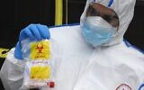 A Magen David Adom paramedic holds a bagged and sealed coronavirus screening test kit during a training exercise in the central city of Kiryat Ono on February 26, 2020. (Jack Guez/AFP)