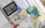 The director of the epidemics service, Dr. Karina Glick, checking a patient's monitor while wearing protective clothing, during a press presentation on hospital services for future patients with coronavirus at Samson Assuta Ashdod University Hospital, on March 16, 2020, in the southern Israeli city of Ashdod. (Jack Guez/AFP)