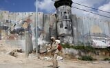 A Palestinian sanitary department worker sprays disinfectant on March 16, 2020 around the refugee camp of Aida near Bethlehem. (Musa Al SHAER / AFP)