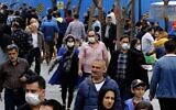 Iranians, some wearing protective masks, gather inside the capital Tehran's grand bazaar, during the coronavirus pandemic crisis, on March 18, 2020 (AFP)