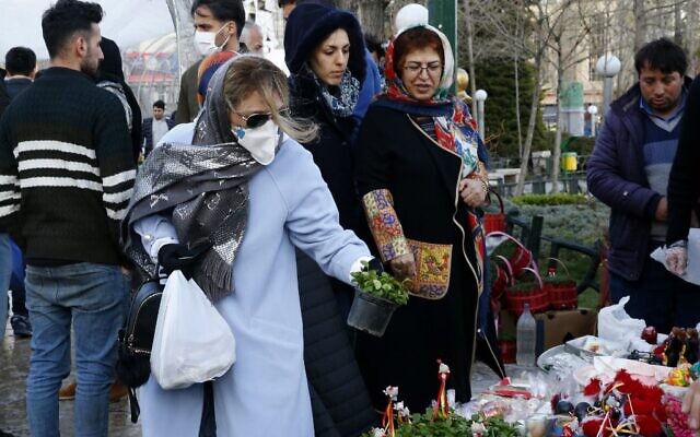 An Iranian woman wearing a protective face mask chooses traditional items ahead of Nowruz, the national New Year 2-week celebration, at the Tajrish Bazaar in the capital Tehran on March 19, 2020, despite the heavy death toll due to infections by the novel coronavirus in the country (STR / AFP) An Iranian woman wearing a protective face mask chooses traditional items ahead of Nowruz, the national New Year 2-week celebration, at the Tajrish Bazaar in the capital Tehran on March 19, 2020, despite the heavy death toll due to infections by the novel coronavirus in the country (STR / AFP)