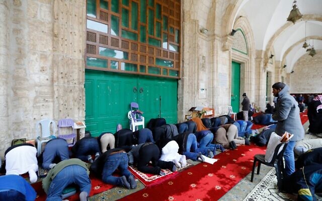 Palestinian Muslims gather to perform their Friday prayers in front of the the closed doors of Al-Aqsa mosque in Jerusalem's Old City, after clerics shut the doors of the mosque and the Dome of the Rock, in a bid to stem the spread of the novel coronavirus, on March 20, 2020. (AHMAD GHARABLI / AFP) Palestinian Muslims gather to perform their Friday prayers in front of the the closed doors of Al-Aqsa mosque in Jerusalem's Old City, after clerics shut the doors of the mosque and the Dome of the Rock, in a bid to stem the spread of the novel coronavirus, on March 20, 2020. (AHMAD GHARABLI / AFP)