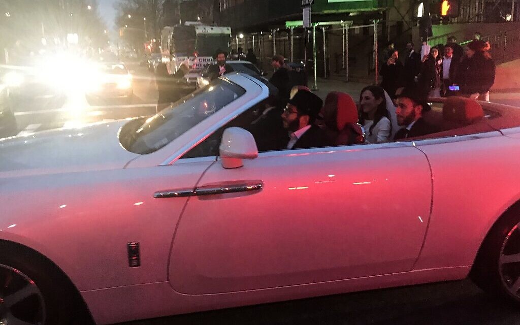Groom JJ Deitch and wife, Fraida, ride in the back of a convertible as people gather for their wedding in Brooklyn on March 19, 2020. (Maggy DONALDSON/AFP) Groom JJ Deitch and wife, Fraida, ride in the back of a convertible as people gather for their wedding in Brooklyn on March 19, 2020. (Maggy DONALDSON/AFP)