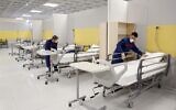 Iranian workers set up a makeshift hospital inside the Iran Mall, northwest of Tehran, on March 21, 2020 amid the coronavirus outbreak. (AFP)