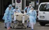 Medical staff use a trolley to move a patient toward a medical helicopter at The Emile Muller Hospital in Mulhouse, eastern France, on March 22, 2020, as patients are evacuated to another hospital facility, on the sixth day of a strict lockdown in France to stop the spread of COVID-19. (SEBASTIEN BOZON / AFP)